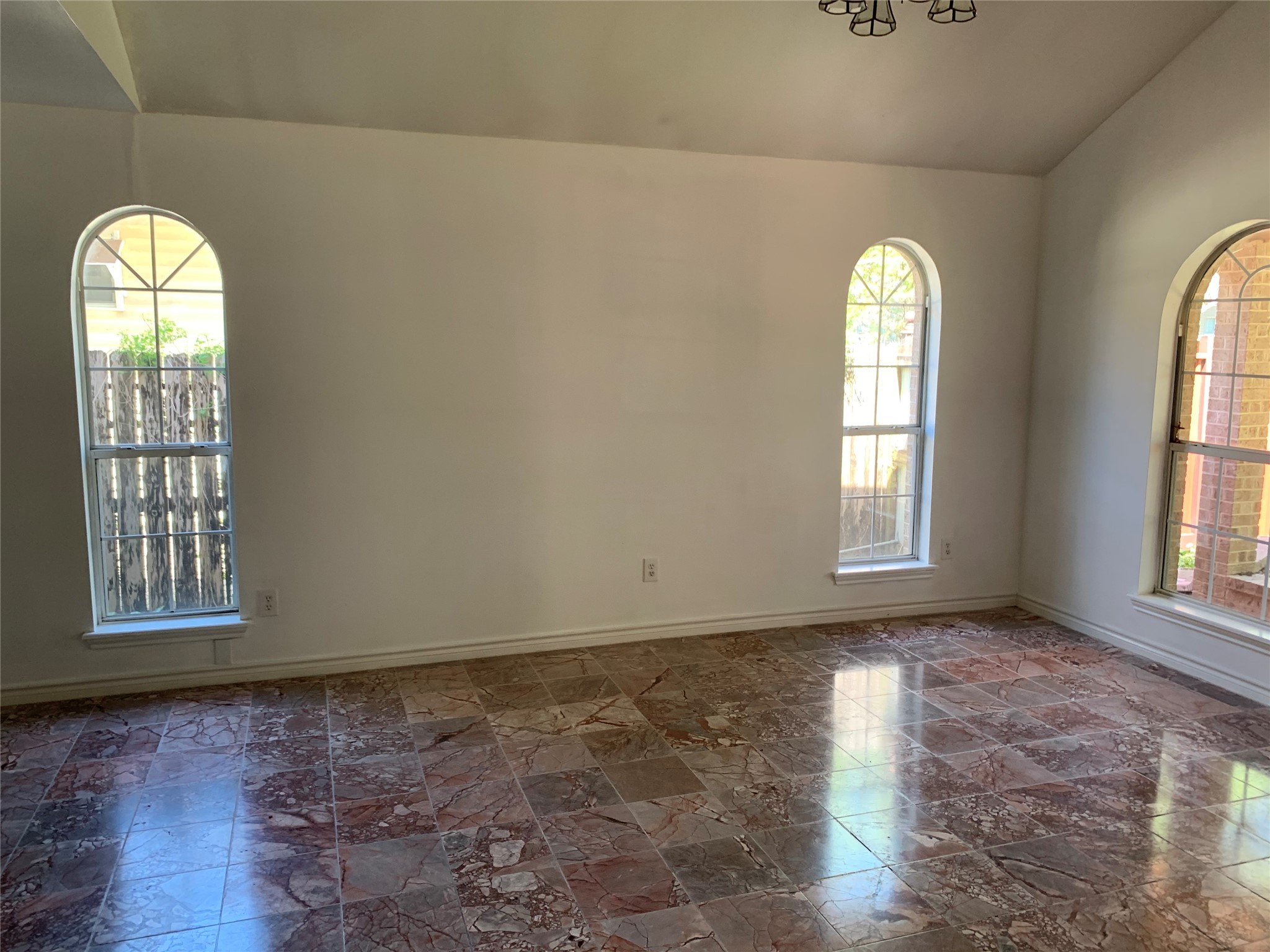4722 Woodside Street Houston, TX 77023 - Photo 4 of 24 an empty room with wooden floor windows and glass door
