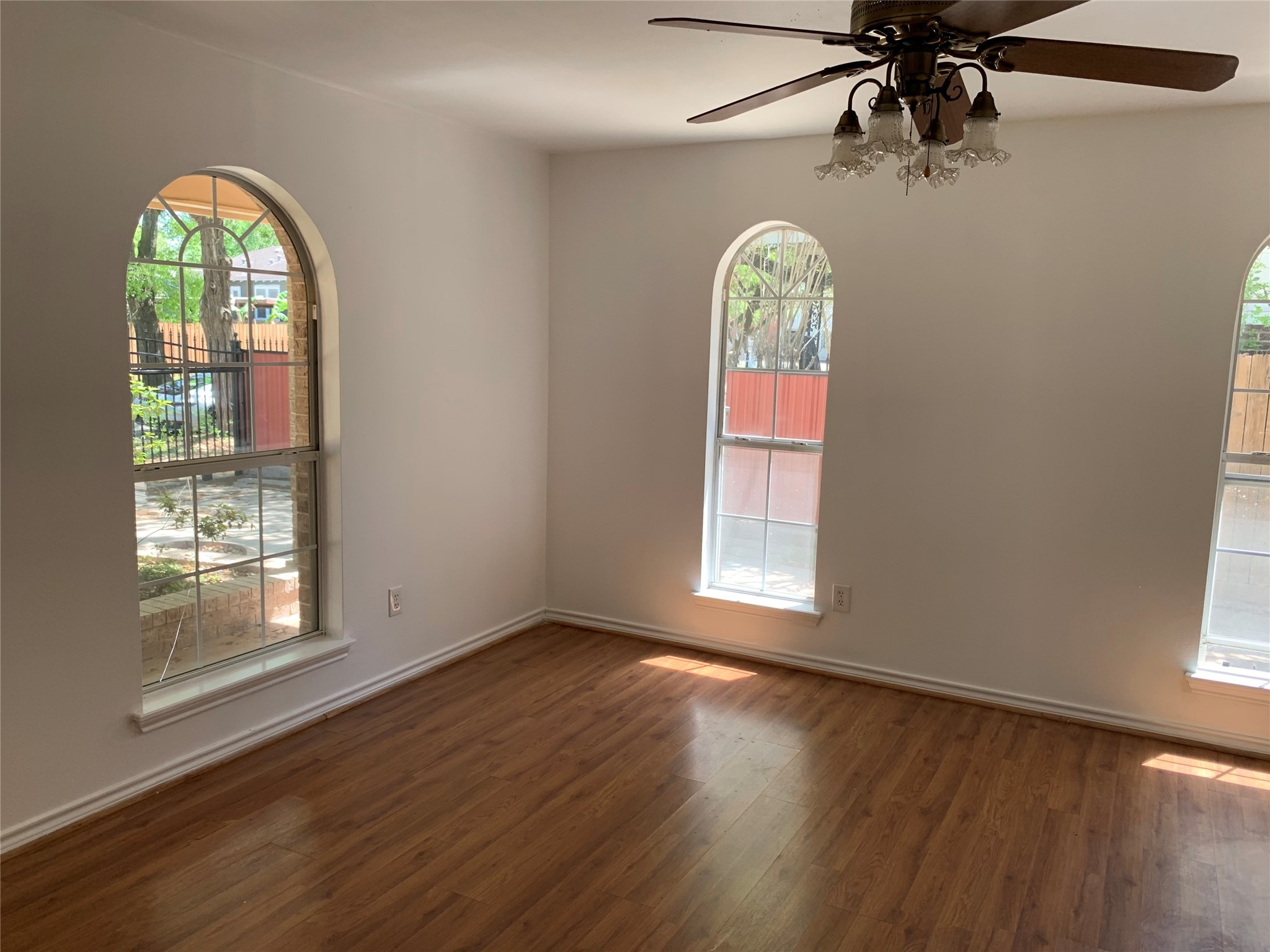 4722 Woodside Street Houston, TX 77023 - Photo 6 of 24 an empty room with wooden floor fan and windows