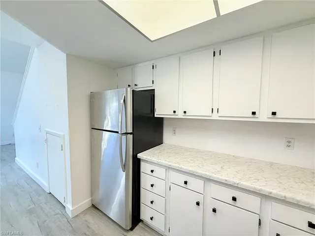 a kitchen with granite countertop cabinets and refrigerator