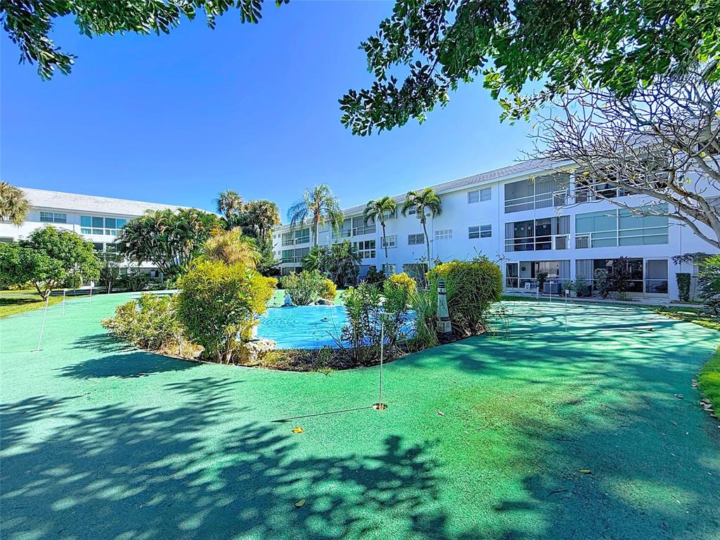 a view of a house with a big yard potted plants and large trees