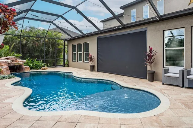 a view of a swimming pool with a patio and a yard