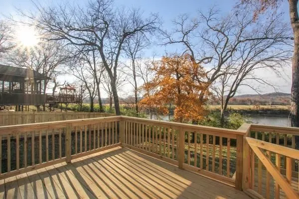a view of a wooden deck with large trees
