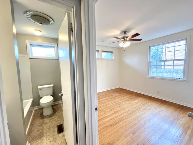 a view of an empty room and a bathroom with a window