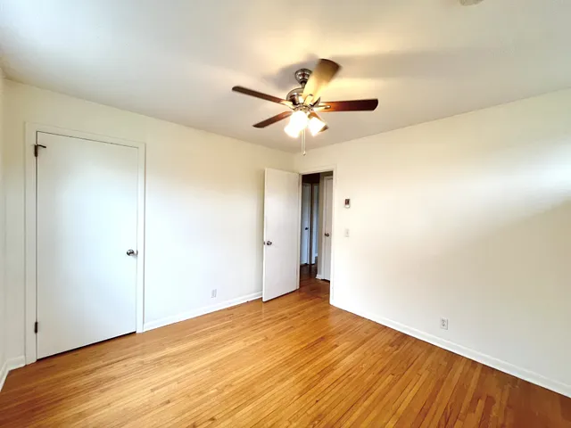 a view of a big room with wooden floor and a ceiling fan