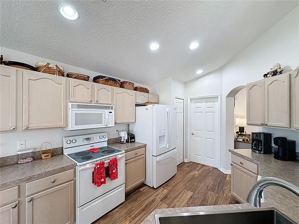 2292 Edmonton Court Clermont, FL 34711 - Photo 19 of 76 a kitchen with a refrigerator and a stove top oven