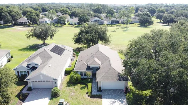 an aerial view of residential houses with outdoor space and river