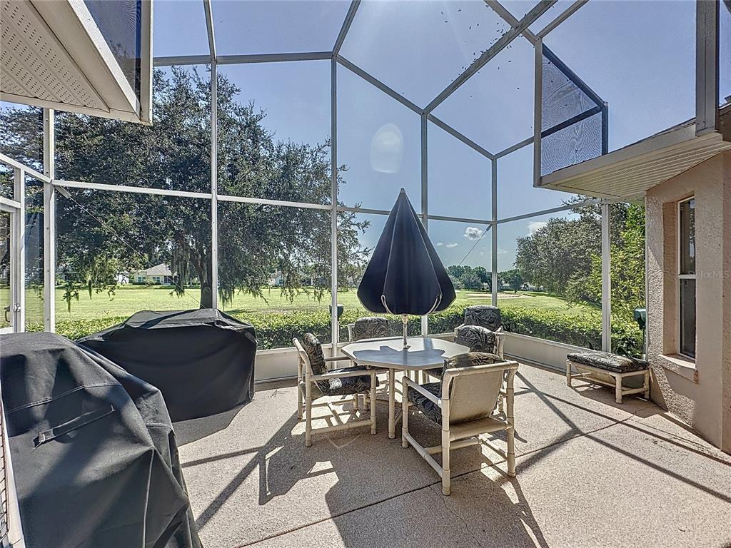 2292 Edmonton Court Clermont, FL 34711 - Photo 37 of 76 a view of a patio with table and chairs under an umbrella