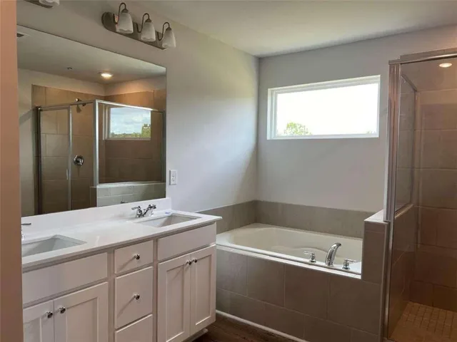 a bathroom with a tub sink and mirror