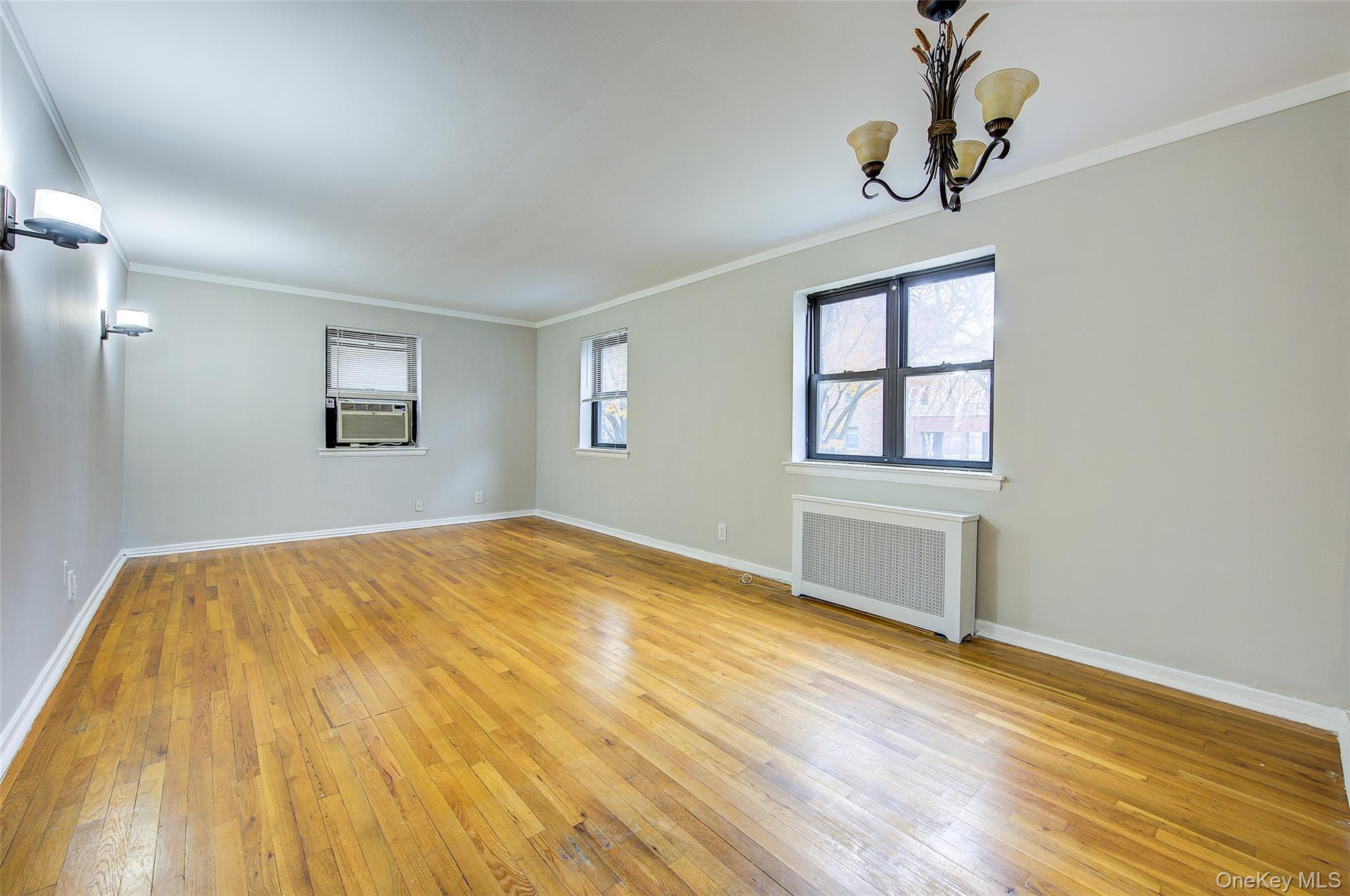 46-42 215th Place, Unit 1C Queens, NY 11361 - Photo 11 of 28 a view of empty room with wooden floor and fan