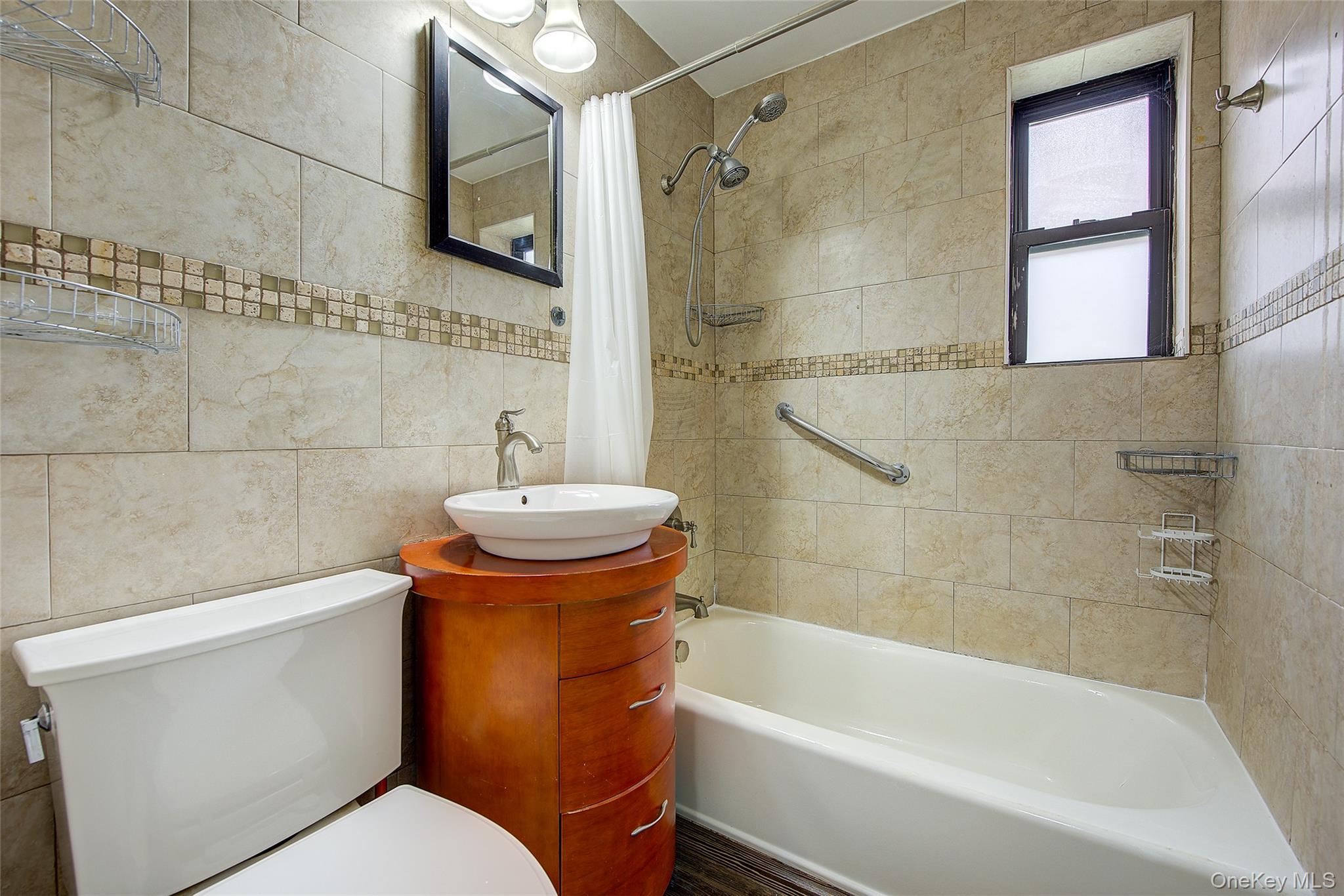 46-42 215th Place, Unit 1C Queens, NY 11361 - Photo 18 of 28 a bathroom with a sink a toilet and bathtub