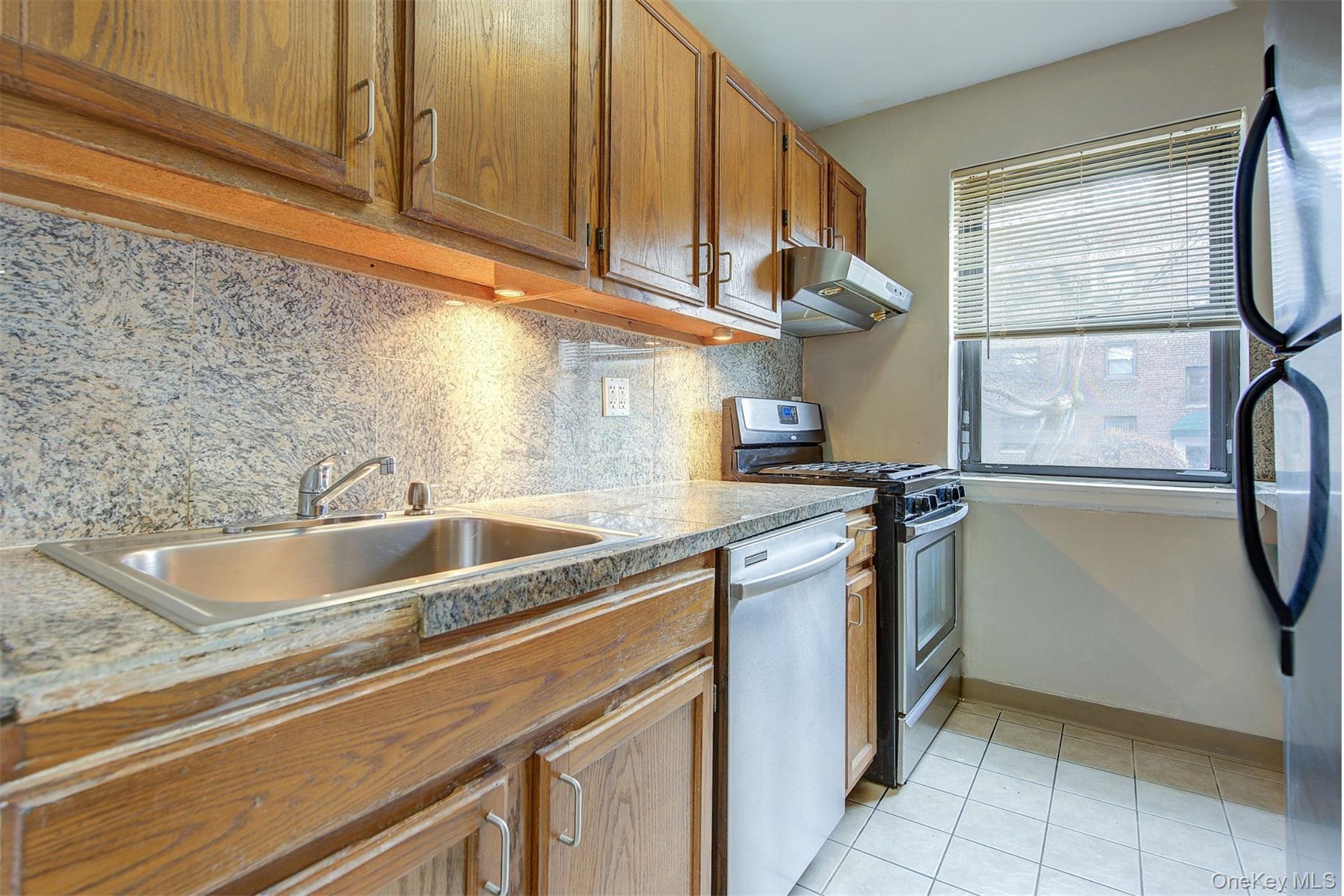 46-42 215th Place, Unit 1C Queens, NY 11361 - Photo 8 of 28 a kitchen with a sink cabinets and a window