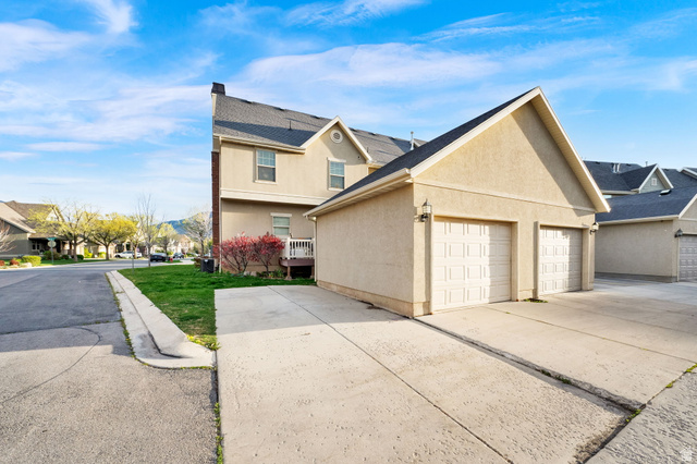 2026 Cres Drive South Mapleton, UT 84664 - Photo 18 of 18 View of side of property with stucco siding, a residential view, concrete driveway, and a garage