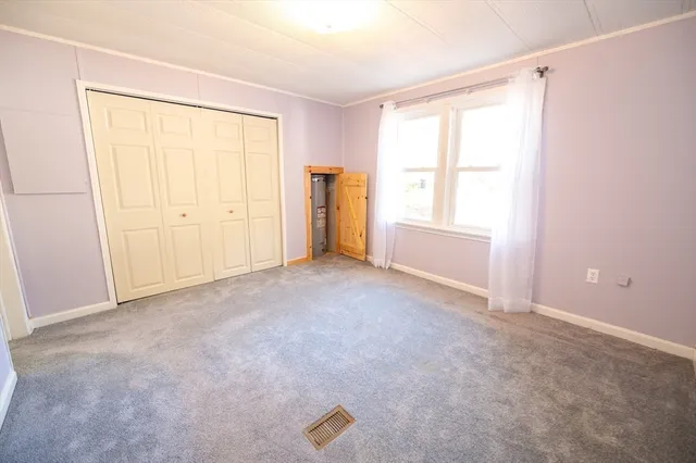 an empty room with windows and closet