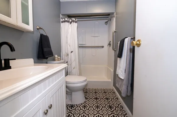 a bathroom with a sink a toilet and shower