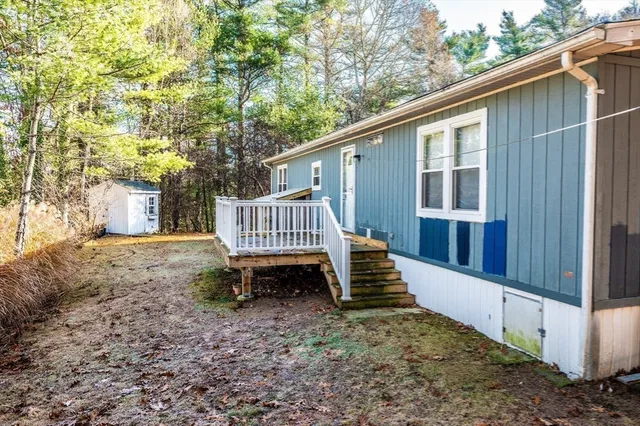 a view of a house with backyard and wooden fence