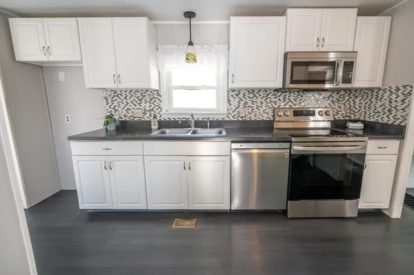a kitchen with granite countertop white cabinets and white stainless steel appliances