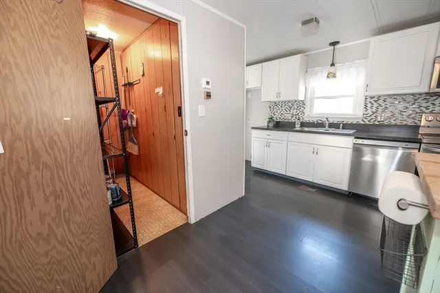 a kitchen with a refrigerator and white cabinets