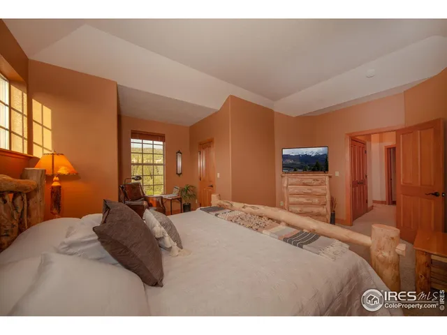 a bedroom with a bed a lamp and a large window