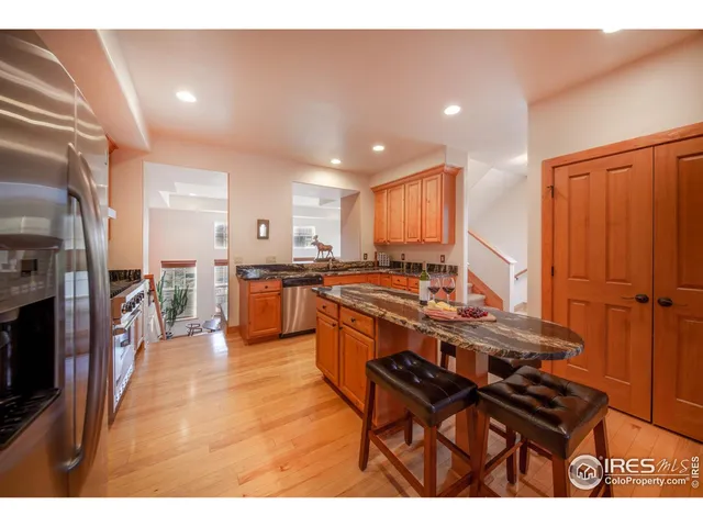 a kitchen with stainless steel appliances granite countertop a stove top oven a sink and a refrigerator