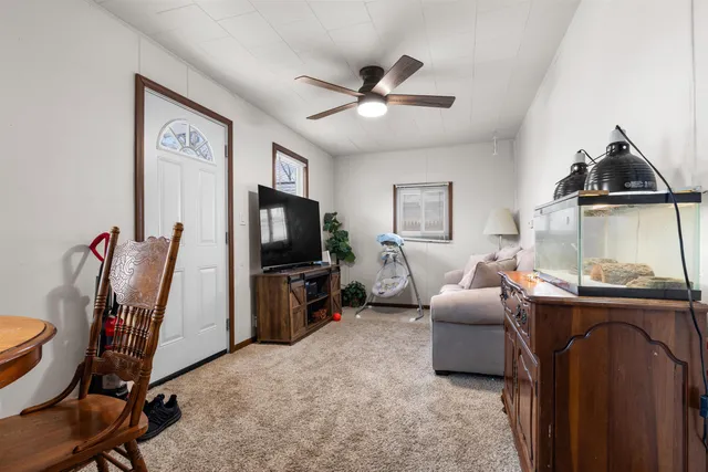 a living room with furniture a flat screen tv and a window