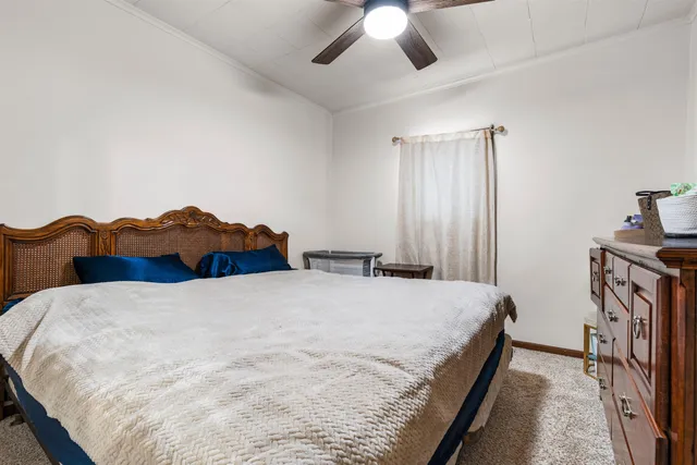 a spacious bedroom with a bed and a chandelier