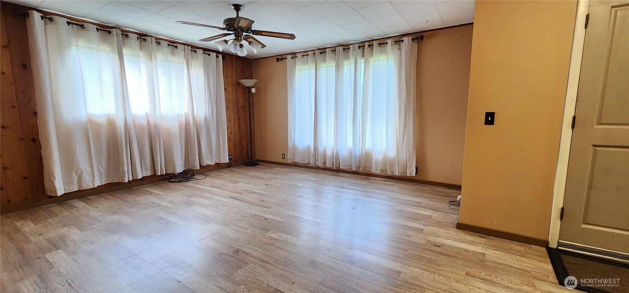 1216 Kaiser Road Southwest Olympia, WA 98512 - Photo 4 of 31 an empty room with wooden floor staircase and windows