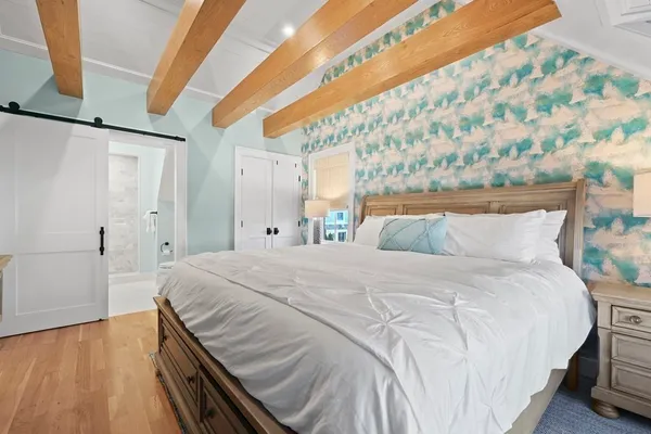 a bedroom with a bed and wooden floor