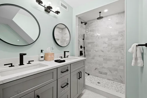 a bathroom with a double vanity sink mirror and shower