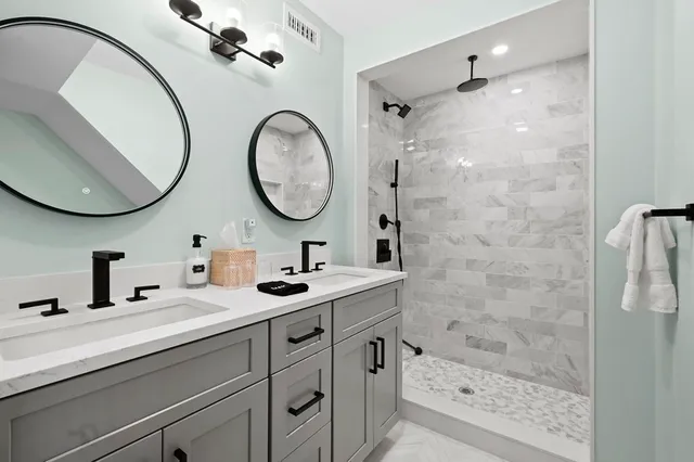 a bathroom with a double vanity sink mirror and shower