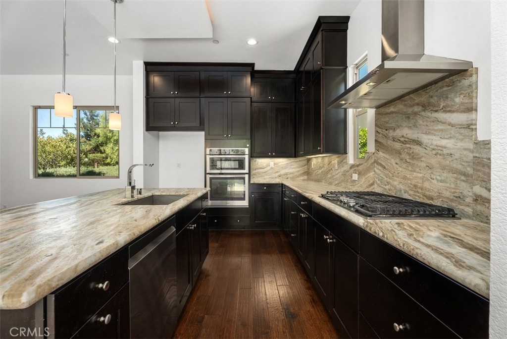 123 Interval Irvine, CA 92618 - Photo 13 of 75 a kitchen with stainless steel appliances granite countertop a sink a stove and a wooden floor