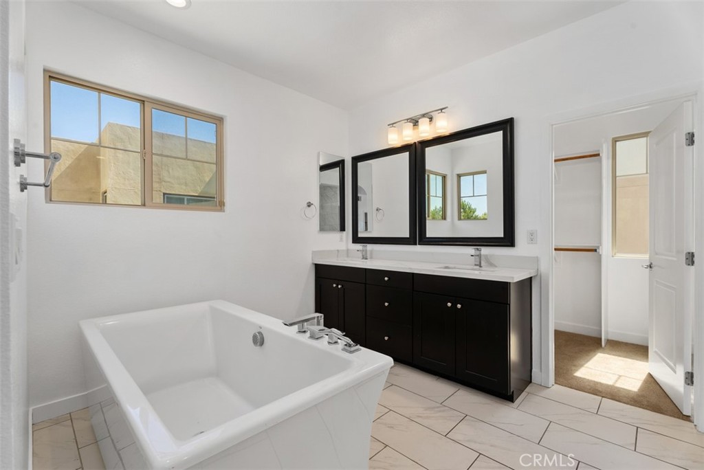 123 Interval Irvine, CA 92618 - Photo 33 of 75 a bathroom with a bathtub sink and mirror