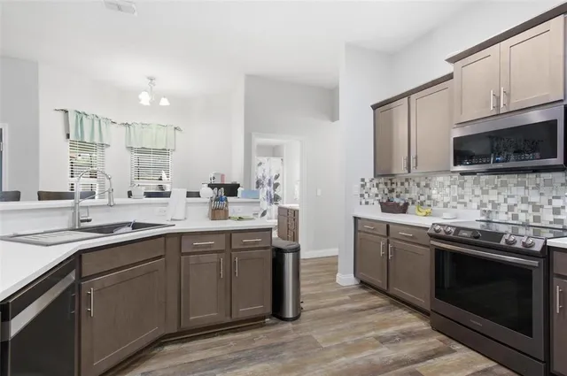 a kitchen with stainless steel appliances granite countertop a sink stove and microwave