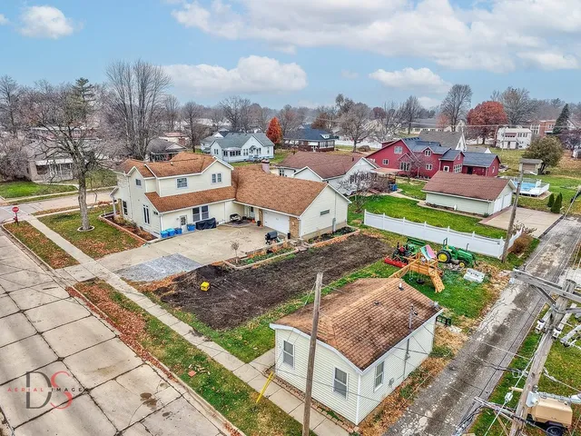 an aerial view of a house with a yard and large trees