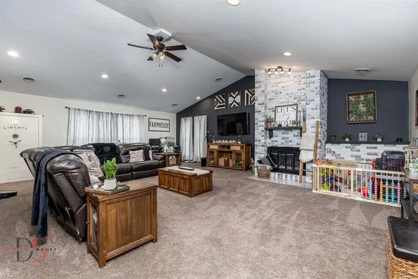 a living room with furniture a fireplace and a flat screen tv