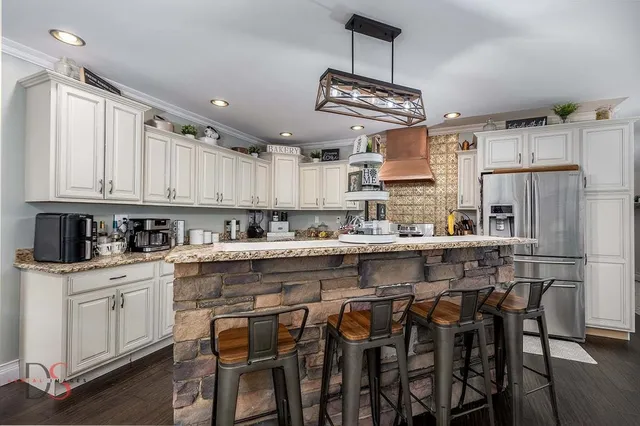 a kitchen with a table chairs refrigerator and cabinets