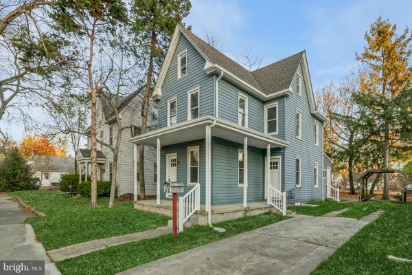 a front view of a house with a yard and potted plants