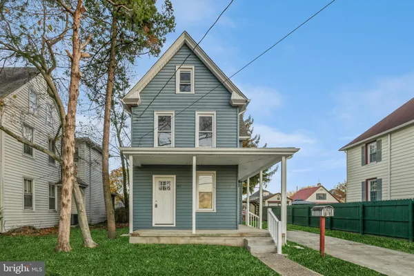 a view of a house with a yard balcony and a large tree