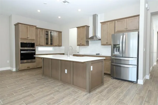 a kitchen with stainless steel appliances granite countertop a refrigerator and a stove top oven