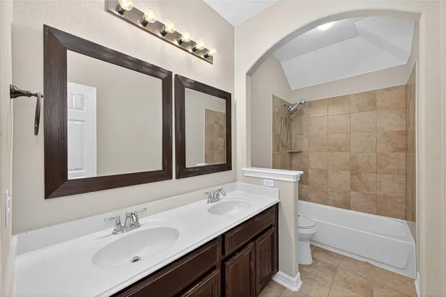 a bathroom with a tub sink and mirror