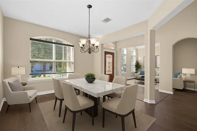 a kitchen with a sink a refrigerator and chairs