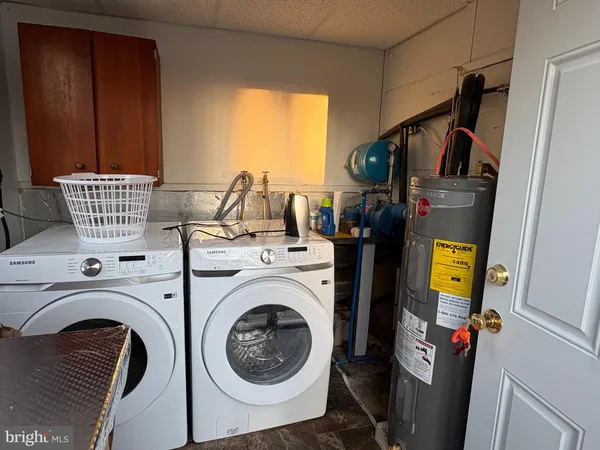 a utility room with dryer washer and a view of living area