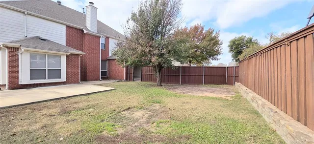a view of backyard with outdoor seating and plants