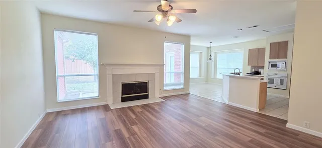a view of a kitchen with wooden floor a fireplace and a window