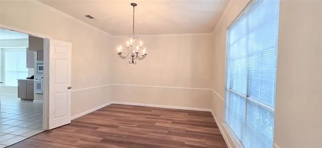 a view of a room with wooden floor and a chandelier