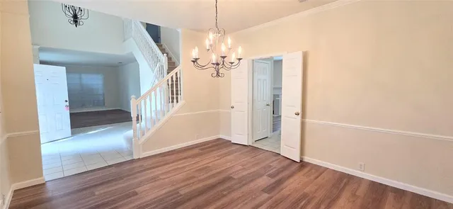 a view of a hallway with wooden floor and stairs