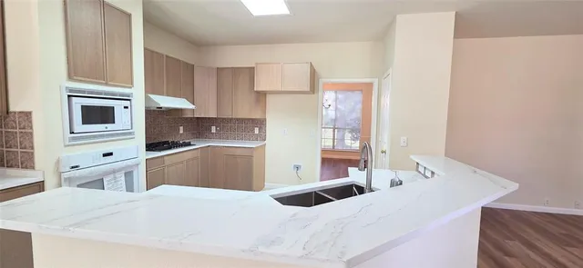 a kitchen with stainless steel appliances kitchen island sink refrigerator and stove