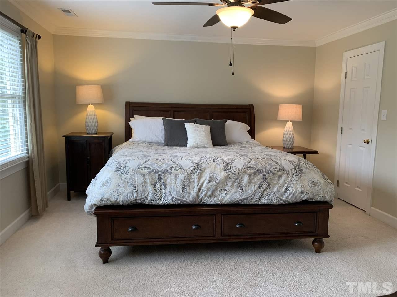 9105 Cub Trail Raleigh, NC 27615 - Photo 11 of 22 a bedroom with a bed and a chandelier