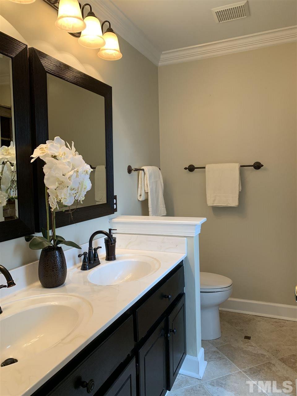 9105 Cub Trail Raleigh, NC 27615 - Photo 12 of 22 a bathroom with a sink a toilet and mirror