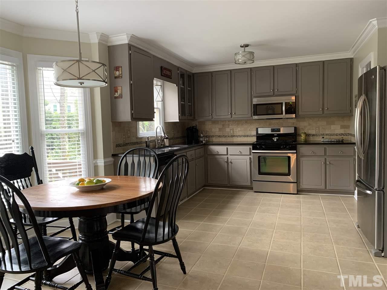9105 Cub Trail Raleigh, NC 27615 - Photo 4 of 22 a kitchen with stainless steel appliances granite countertop a sink a stove a table and chairs