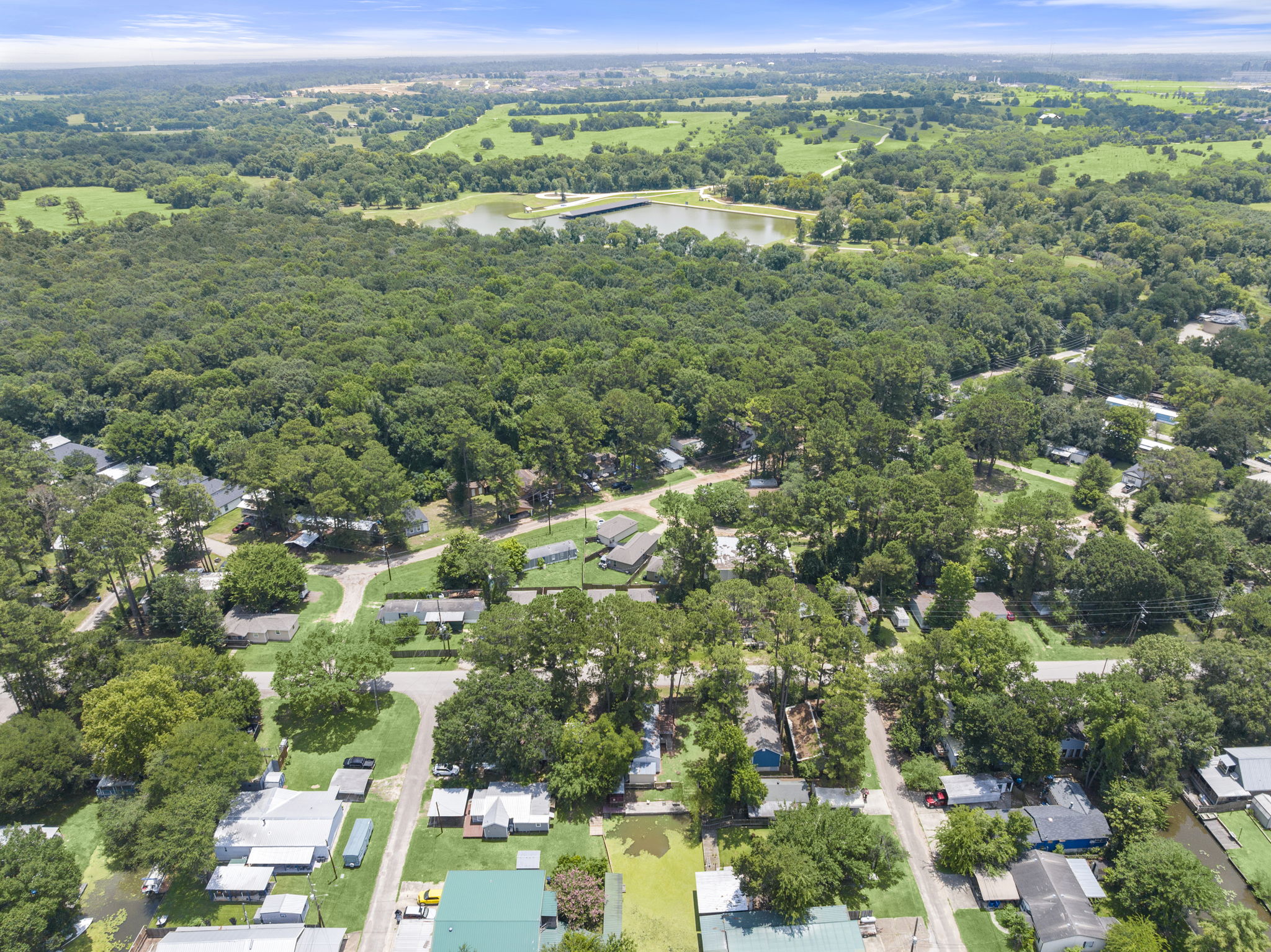 9649 Warm Spring Willis, TX 77318 - Photo 25 of 30 An aerial perspective reveals a serene community nestled amidst verdant forests and an idyllic lake.